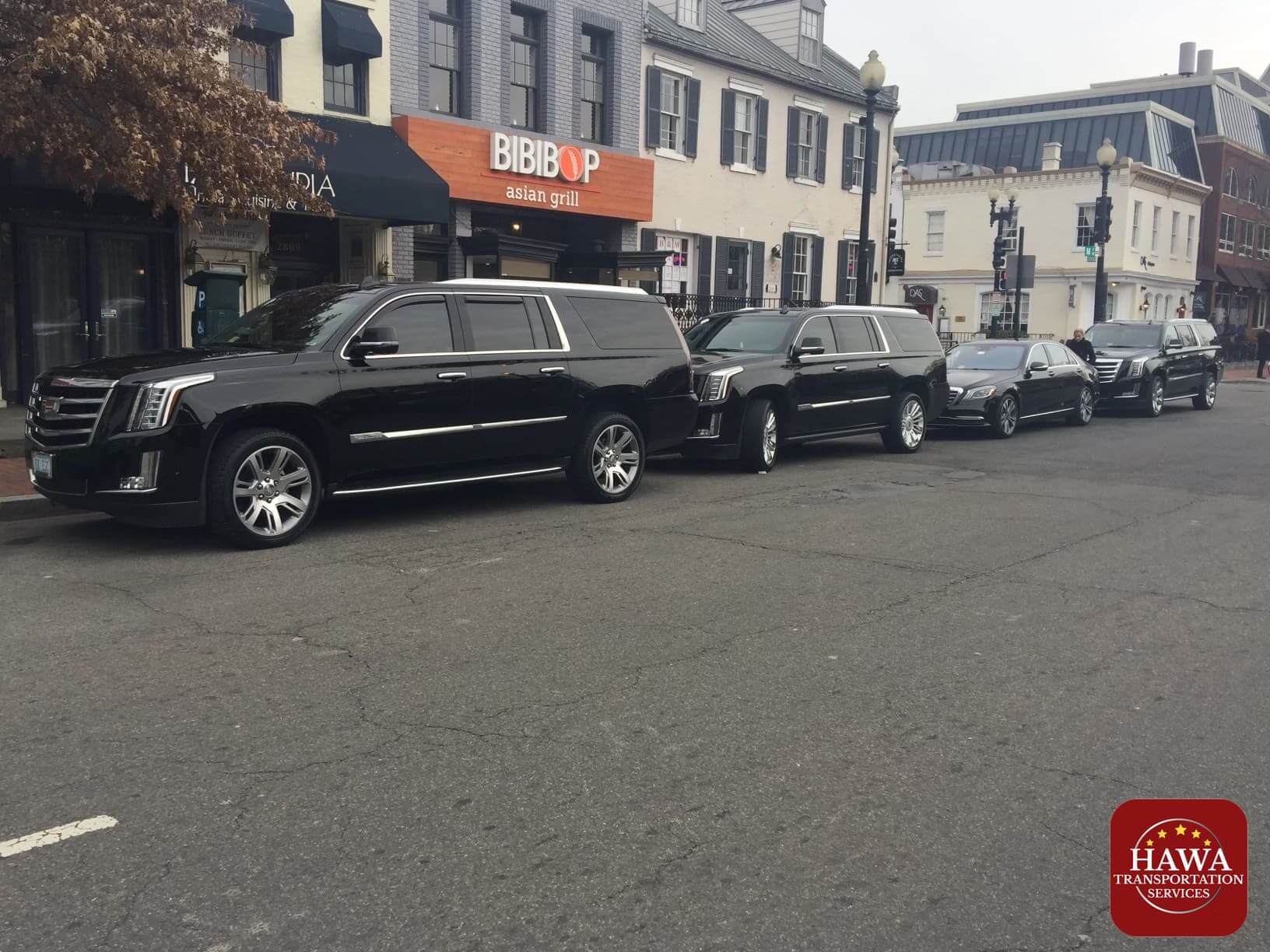 Black SUVs lined up near storefronts