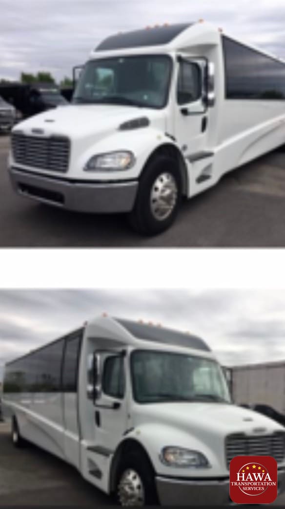 A white bus is parked in the lot and there are no people.