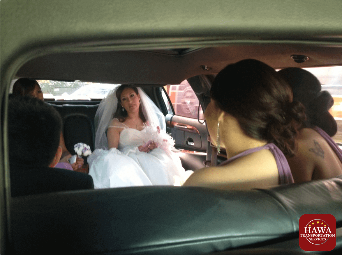 Bride holding bouquet in limo with bridesmaids