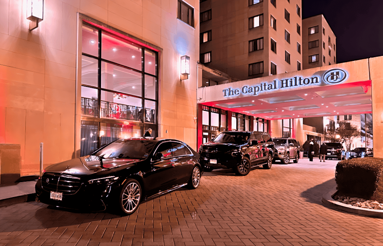 Black car parked in front of hotel.