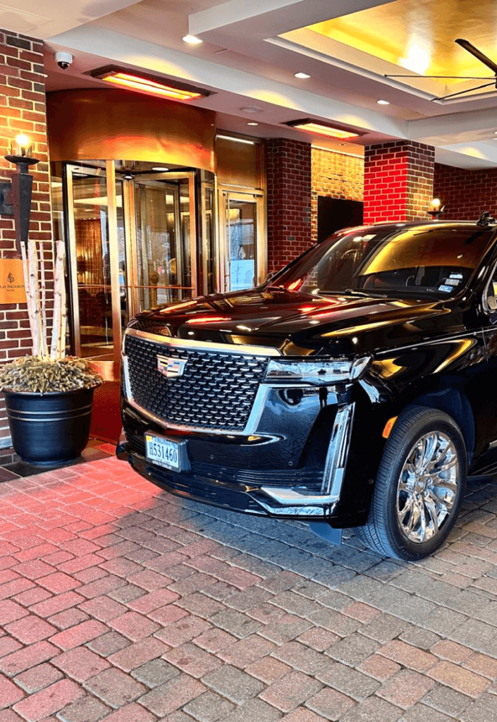 Black Cadillac SUV parked in front of building.